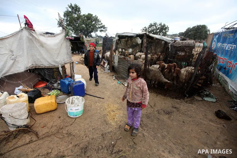 A Palestinian Beduin girl play next to her tent as wintry weather swept through the region, in Gaza city on 10 January 2013. Abnormal storms, which for four days have blasted the Middle East with rain, snow and hail, lea...