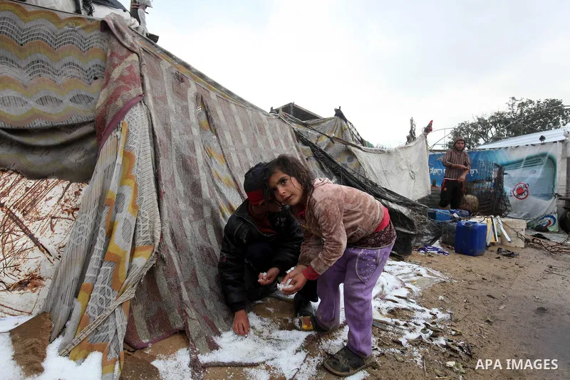 A Palestinian Beduin girl play in snow next to her tent as wintry weather swept through the region, in Gaza city on 10 January 2013. Abnormal storms, which for four days have blasted the Middle East with rain, snow and h...