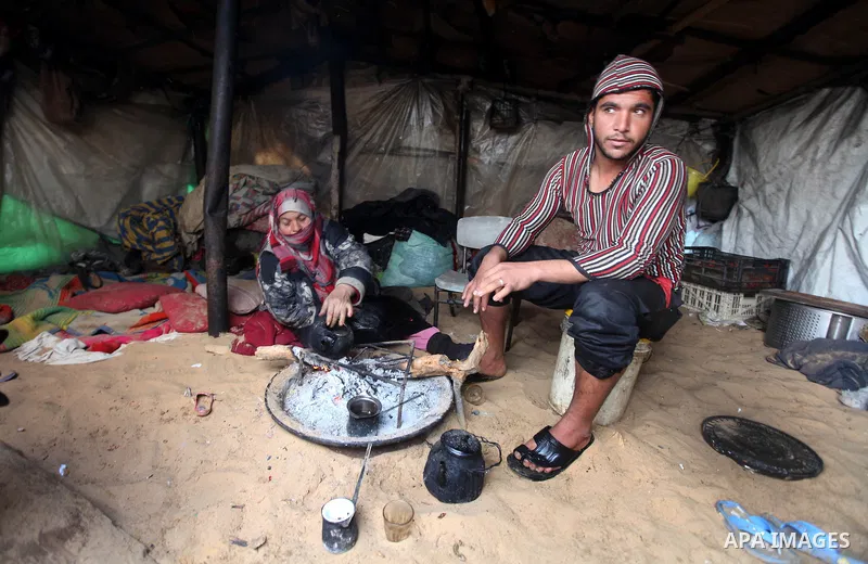 Palestinian Beduins warm themselves as wintry weather swept through the region, in Gaza city on 10 January 2013. Abnormal storms, which for four days have blasted the Middle East with rain, snow and hail, leave swathes o...