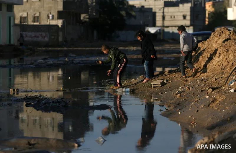 Palestinian children walk past a flooded street after heavy storms in Rafah refugee camp southern Gaza strip on 11 january 2013. In Gaza, cold weather and heavy rain flooded several of the tunnels running between the ter...