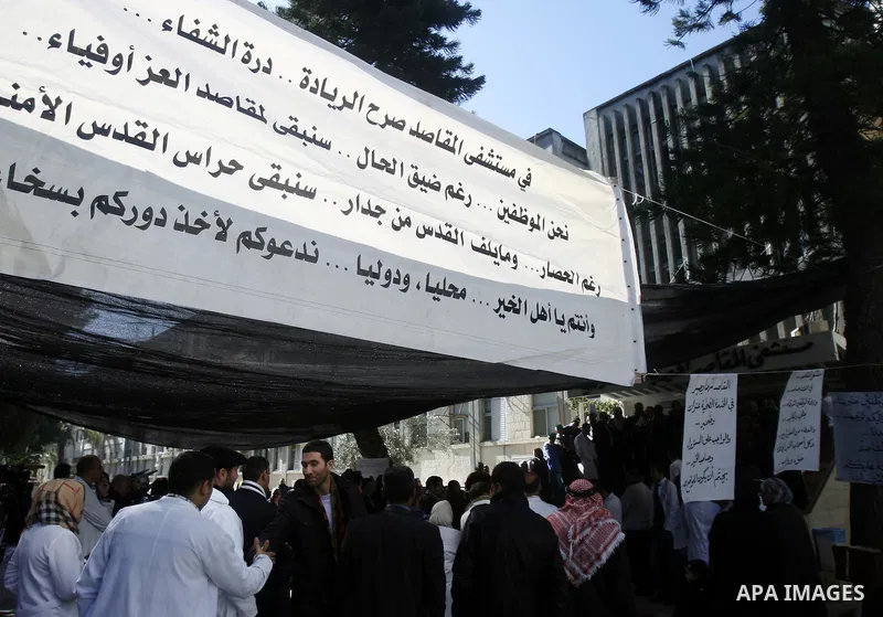 Palestinian health employees protest in front of al-Maqased hospital to demand the Palestinian government to pay their salaries, in Jerusalem on 14 January 2013. Palestinian Prime Minister Salam Fayyad warned Sunday that...