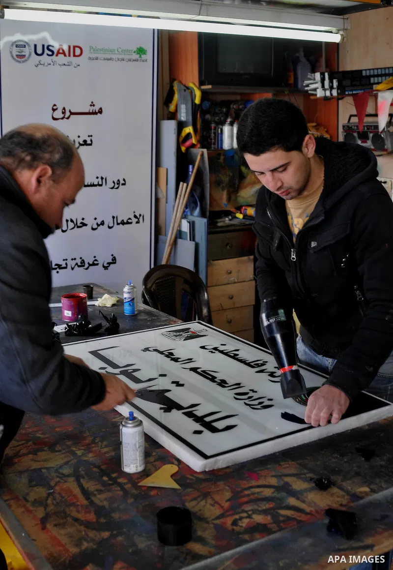 Palestinian calligraphers write "State of Palestine" on a signboard in the West Bank city of Hebron on 15 January 2013. Israeli Prime Minister Benjamin Netanyahu has rejected the decision by Palestinian National Authorit...