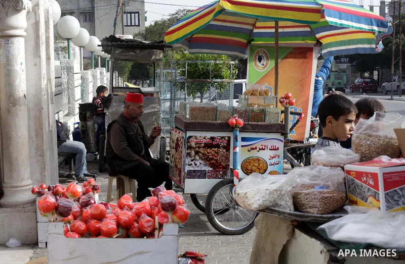 A Palestinian vendor sells nuts in front of a park during the semester break, in Gaza city on 16 January 2013. Photo by Ashraf Amra