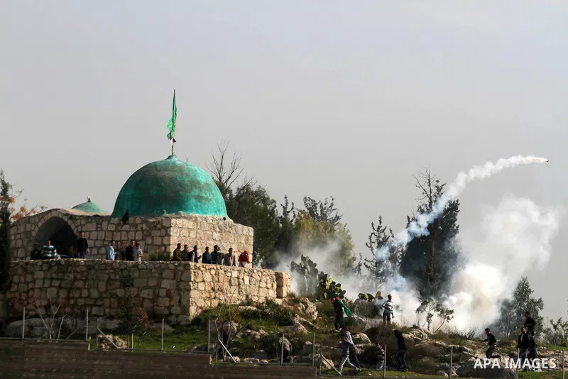 Palestinian protesters run for cover from tear gas fired by Israeli soldiers during a demonstration in the village of Budrus, west of Ramallah, on January 18, 2013. The Palestinians are bracing for a new right-wing gover...