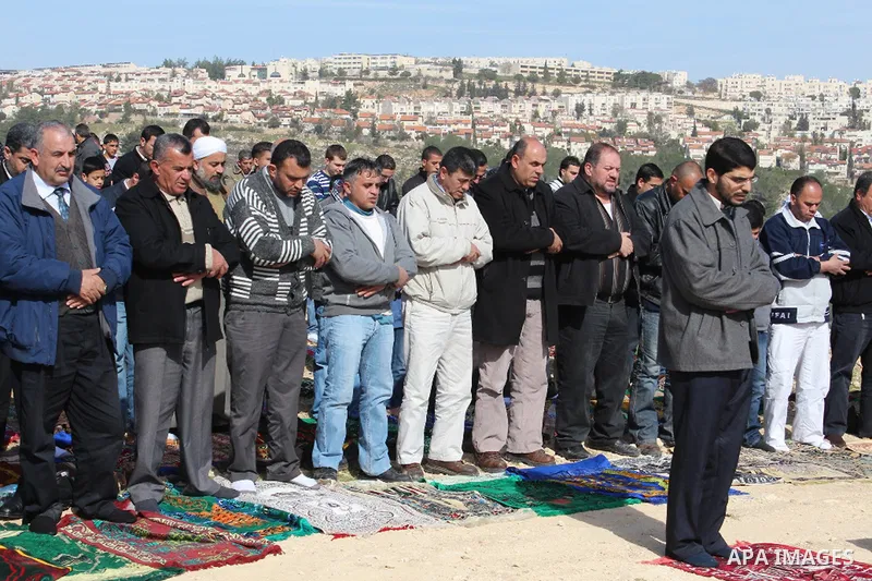 Palestinian activists pray near the new "outpost" named Bab al-Karama ("gate of the honor") in the village of Beit Iksa, northwest of Jerusalem, January 18, 2013. The Palestinian activists built the outpost on a disputed...