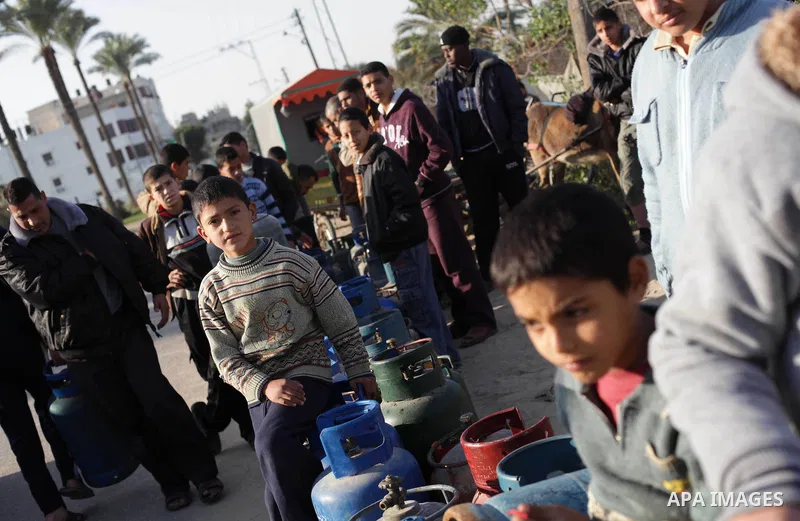 Palestinians wait to fill gas cylinders at a gas station in Gaza City, Jan. 20, 2013. Local officials said that the consumption of cooking gas mainly in houses, bakeries, hospitals, restaurants and farms during winter in...