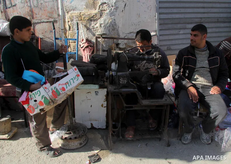 A Palestinian shoemaker works in his shop at al-Zawiya popular market in Gaza city, January 20, 2013. Photo by Ezz al-Zanoon