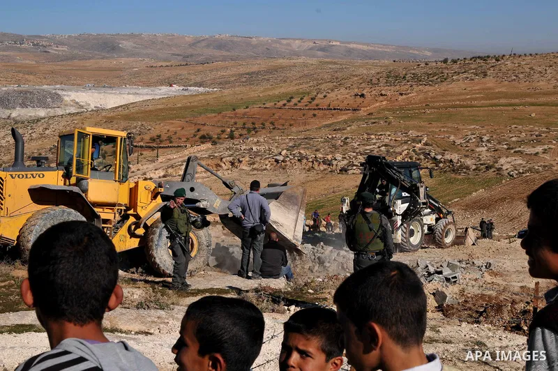 Palestinians are restrained by Israeli soldiers as Israeli bulldozers demolish man-made reservoir near the village of Yatta, near the West Bank city of Hebron, 21 January 2013. The reservoir was reportedly located in a c...
