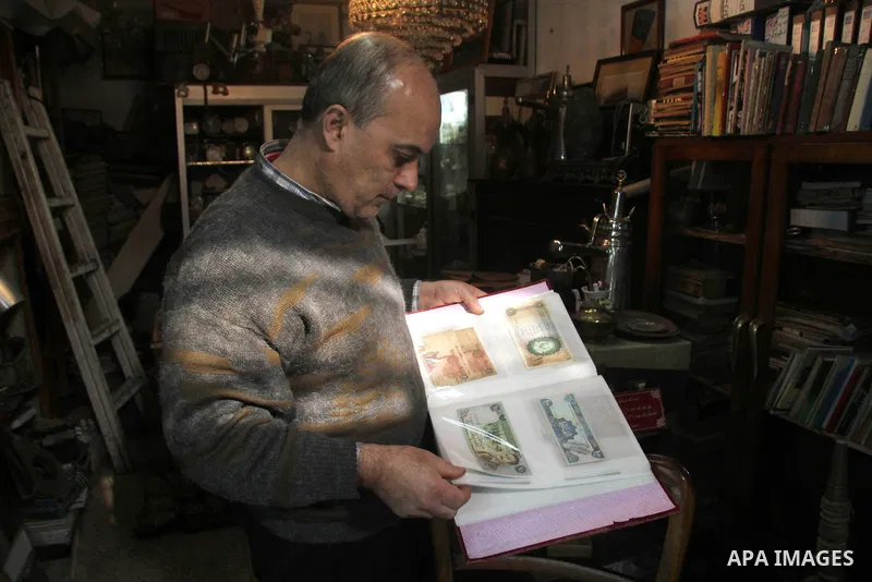 A Palestinian vendor displays old banknotes, in his antiques store in Gaza city on January 20, 2013. Photo by Ezz al-Zanoon