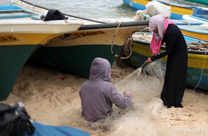 Madlin, a Palestinian girl, 18 years old, helps her brother to fix a fishing net at Gaza's seaport, in Gaza city on January 23, 2013. Madlin is the first girl fix professionally fishing nets in order to support her poor...