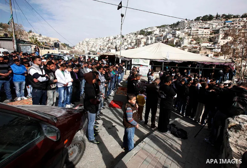 Palestinian Muslim worshippers attend Friday prayers outside a sit-in tent against the continuing 'Judaization of Jerusalem' by Jewish settlers, in the mostly Arab neighbourhood of Silwan in east Jerusalem on Jan. 25, 20...