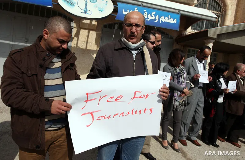 Palestinian journalists hold placards during a demonstration in support with reporters detained by Hamas in Gaza and to ask for their immediate release on January 27, 2013 in the West Bank city of Ramallah. Photo by Issa...