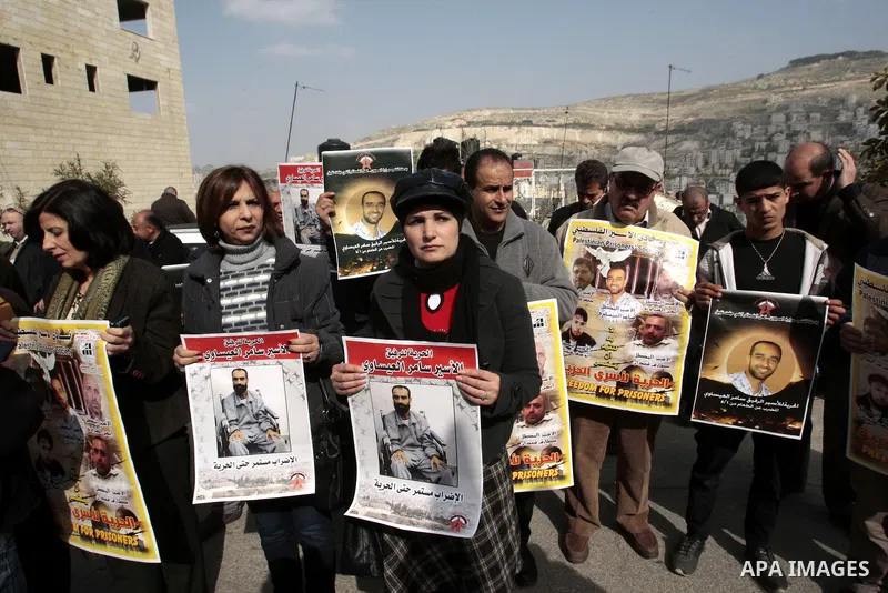 Palestinians take part in a protest calling for the release of Palestinian prisoners from Israeli jails in front of the Red cross office in the West Bank city of Hebron, Jan. 28, 2013. Photo by Nedal Eshtayah