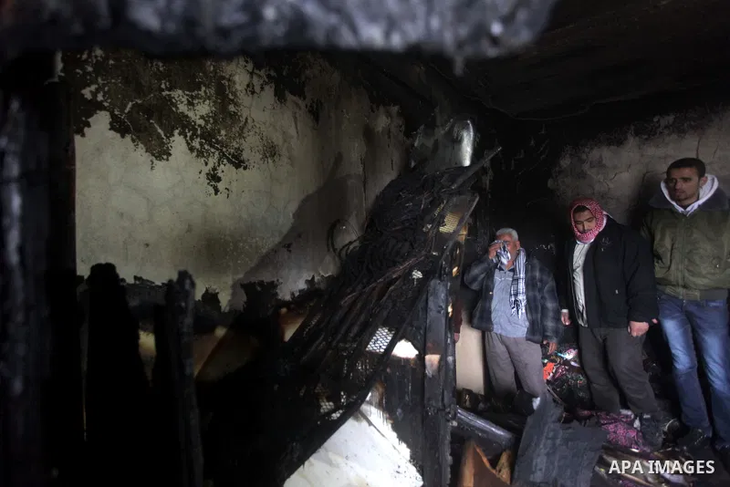 Palestinians inspect the damage in the bedroom to the Dhuheir family have led to six deaths after a fire from a candle that swept through their home in Shijaia in the east Gaza city on Jan. 31, 2013 The Dhuheir family wa...