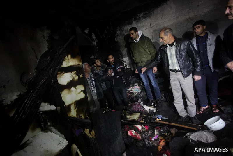 Palestinians inspect the damage in the bedroom to the Dhuheir family have led to six deaths after a fire from a candle that swept through their home in Shijaia in the east Gaza city on Jan. 31, 2013 The Dhuheir family wa...