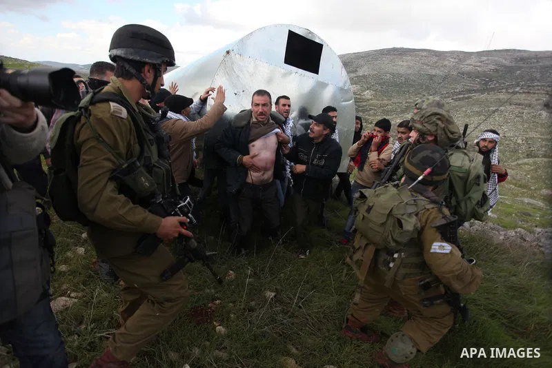 Israeli security forces detain a Palestinian activist during a protest against Jewish settlements near the West Bank village of Burin, Saturday, Feb. 2, 2013. Israeli troops fired tear gas and stun grenades at rock-throw...