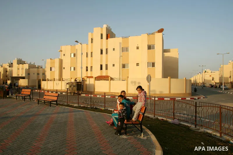 Palestinian children play near the new houses handed by the United Nations Relief and Works Agency for Palestine Refugees (UNRWA) to the refugee families whose houses have been demolished by Israel in Rafah, in the south...