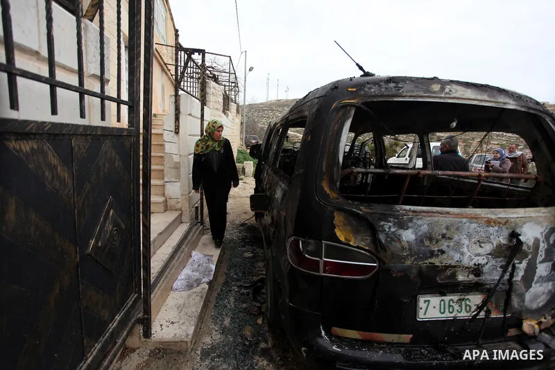 Palestinians inspects a burnt vehicle following an apparent price tag attack by Jewish settlers in the West Bank village of Deir Jarir, northeast of Ramallah, on February 5, 2013. Suspected Jewish extremists torched a ve...