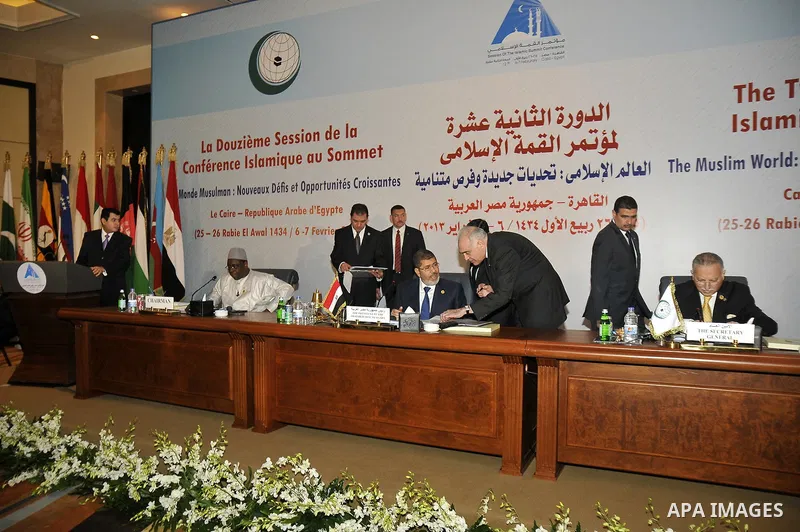 Egyptian President Mohammed Morsi (L) and his Foreign minister Mohammed Kamel Amr (R) talk during the 12th summit of the Organisation of Islamic Cooperation on February 6, 2013 in Cairo. The 12th summit of the Organisati...