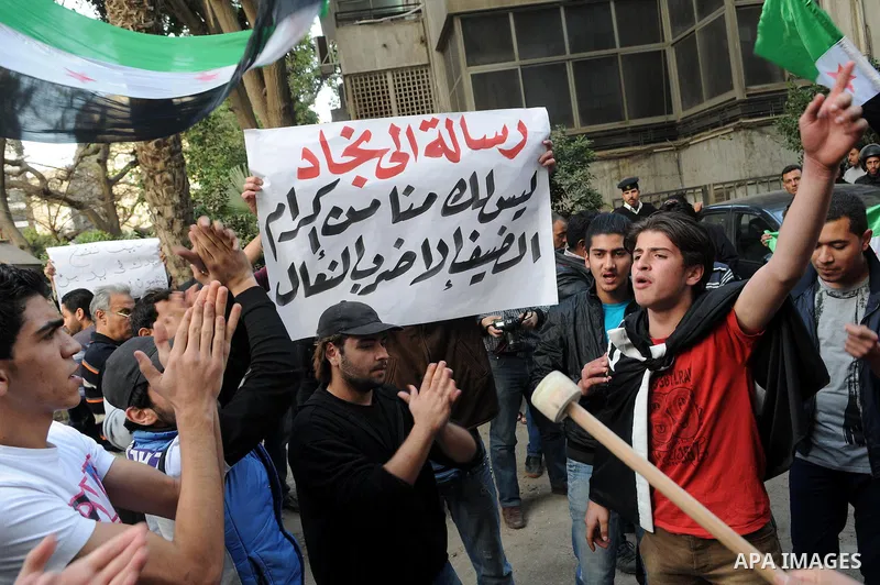 Protesters wave the pre-Baath Syrian flag, now used by the Free Syrian Army, as they shout slogans against the Syrian and Iranian regimes during a demonstration outside the Iranian embassy in the Egyptian capital Cairo o...