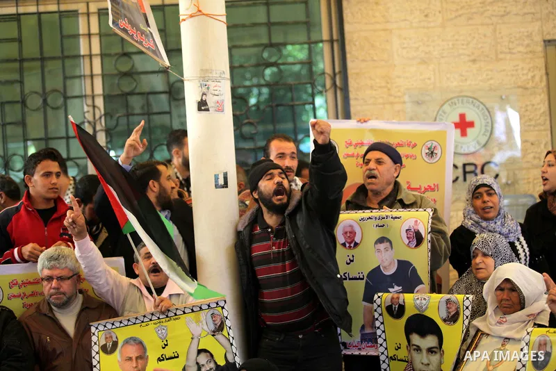 Palestinian women hold pictures of prisoners held in the Israeli jails during a protest calling for the release of Palestinian prisoners from Israeli jails in front of the Red cross office in Gaza city, Feb. 11, 2013. Ph...