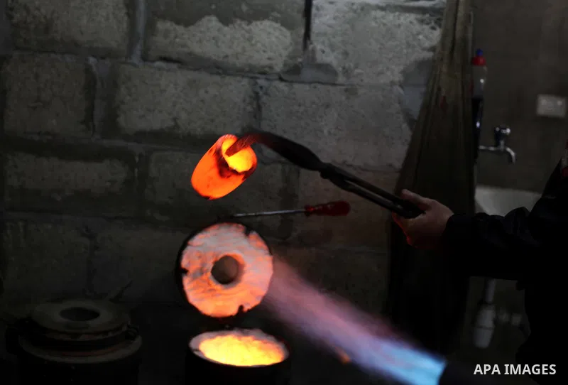 A Palestinian jeweller melts gold at his workshop in Gaza city on February 18, 2013. Photo by Ashraf Amra