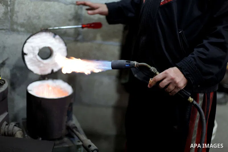 A Palestinian jeweller melts gold at his workshop in Gaza city on February 18, 2013. Photo by Ashraf Amra