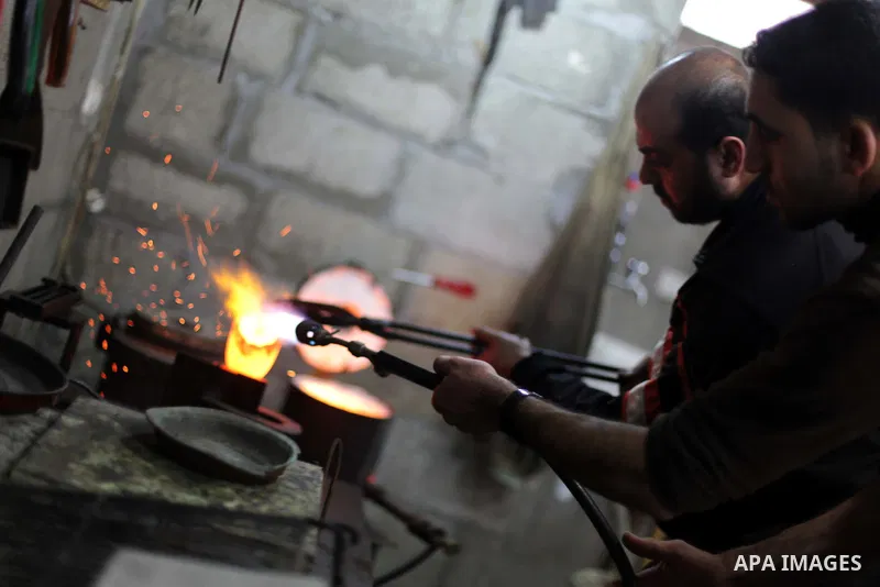A Palestinian jeweller melts gold at his workshop in Gaza city on February 18, 2013. Photo by Ashraf Amra