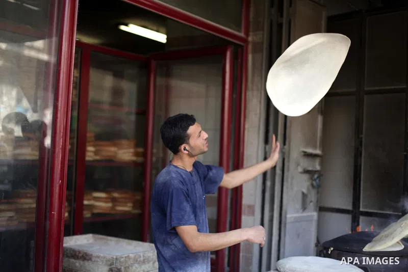 A Palestinian baker prepares bread at his bakery in Gaza city on February 21, 2013. Photo by Ashraf Amra