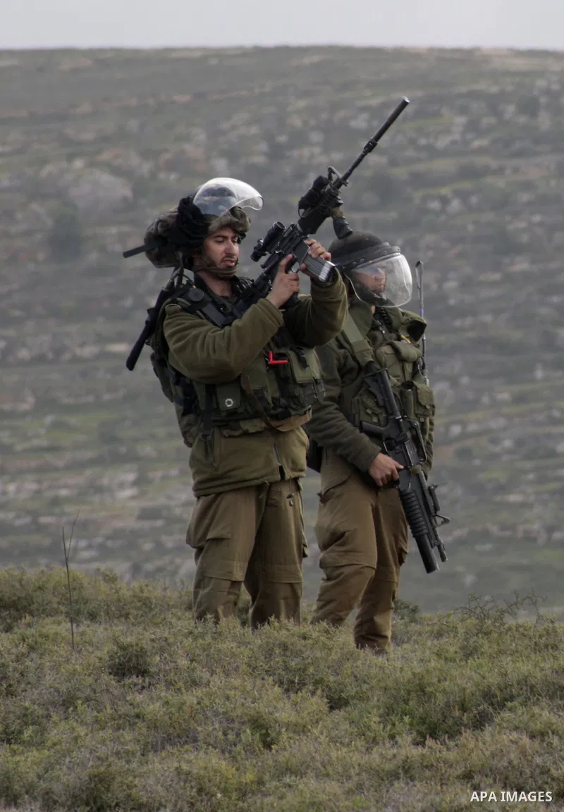 An Israeli soldier fires tear gas at Palestinian protesters during a protest against the expanding of Jewish settlement in Qusra village near the West Bank city of Nablus on Feb. 23 , 2013. Photo by Nedal Eshtayah