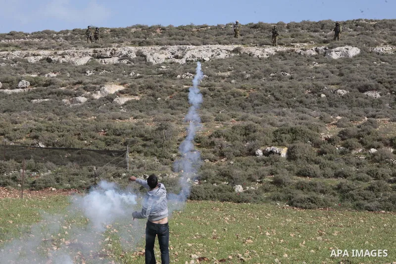 A Palestinian protestor throws stones towards Israeli soldiers during a protest against the expanding of Jewish settlement in Qusra village near the West Bank city of Nablus on Feb. 23 , 2013. Photo by Nedal Eshtayah