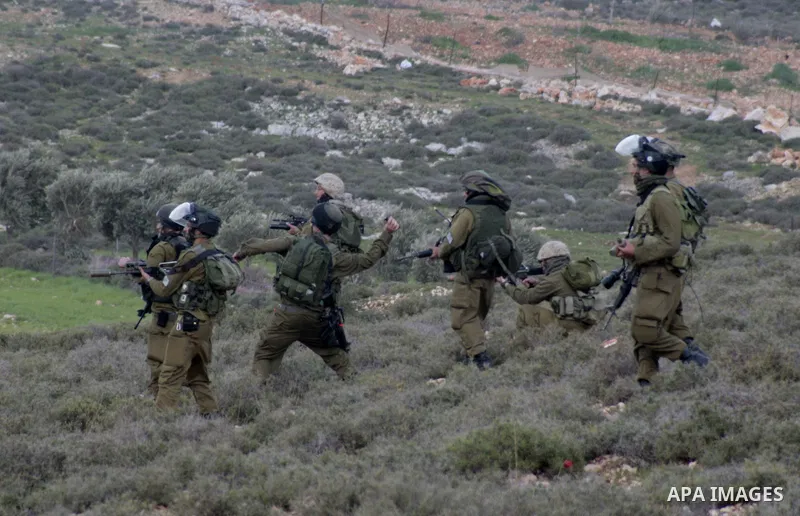 An Israeli soldier fires tear gas at Palestinian protesters during a protest against the expanding of Jewish settlement in Qusra village near the West Bank city of Nablus on Feb. 23 , 2013. Photo by Nedal Eshtayah