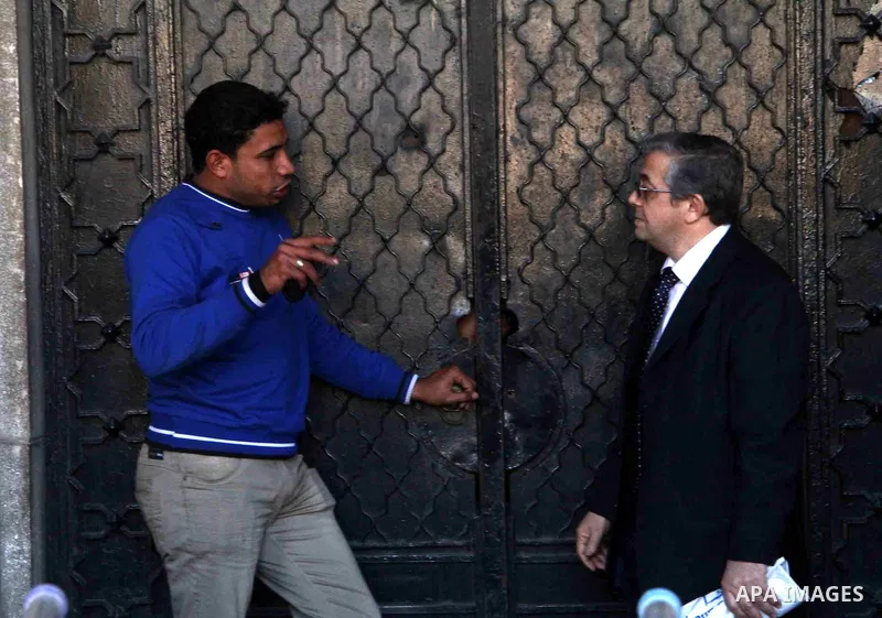 Egyptians stand at the entrance of the Mugamma, Cairo's main administrative building on February 24, 2013 part of a growing campaign of civil disobedience around the country. A group of protesters closed the doors of the...