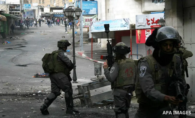 Israeli security forces stand opposite Palestinian protesters during clashes in the West Bank city of Hebron, on February 24, 2013 following the death of a Palestinian prisoner held in Israel. Some 3,000 Palestinians hel...