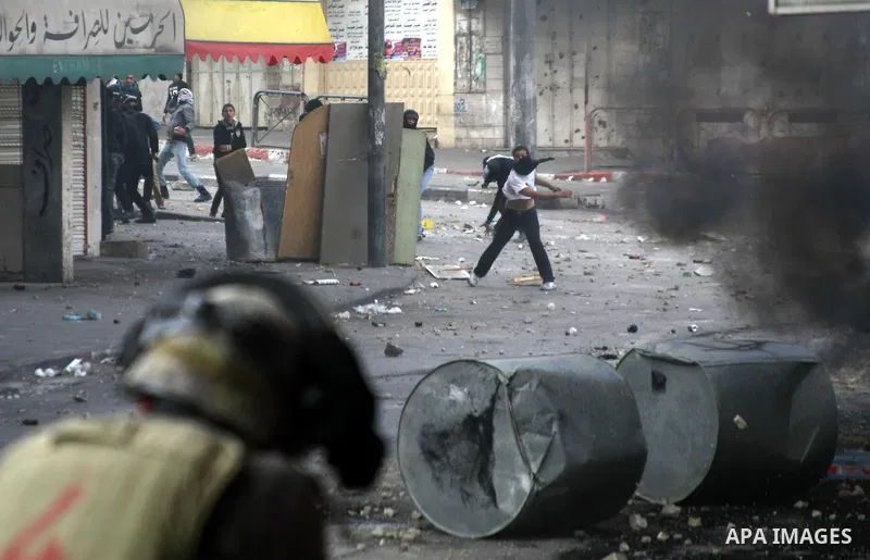 Palestinian protesters throw stones towards Israeli security forces during clashes in the West Bank city of Hebron, on February 24, 2013 following the death of a Palestinian prisoner held in Israel. Some 3,000 Palestinia...
