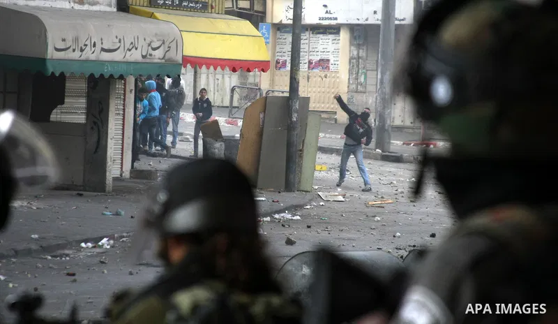 Palestinian protesters throw stones towards Israeli security forces during clashes in the West Bank city of Hebron, on February 24, 2013 following the death of a Palestinian prisoner held in Israel. Some 3,000 Palestinia...