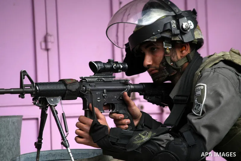 An Israeli security sniper rubbers at Palestinian protesters during clashes in the West Bank city of Hebron, on February 24, 2013 following the death of a Palestinian prisoner held in Israel. Some 3,000 Palestinians held...