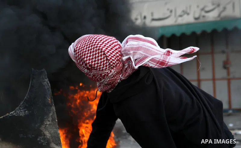 A Palestinian protester throws stones towards Israeli security forces during clashes in the West Bank city of Hebron, on February 24, 2013 following the death of a Palestinian prisoner held in Israel. Some 3,000 Palestin...