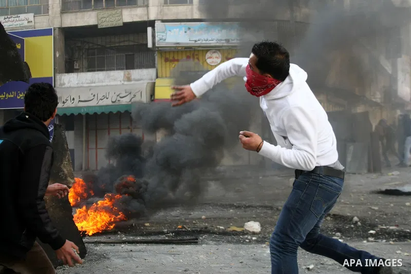 Palestinian protesters throw stones towards Israeli security forces during clashes in the West Bank city of Hebron, on February 24, 2013 following the death of a Palestinian prisoner held in Israel. Some 3,000 Palestinia...