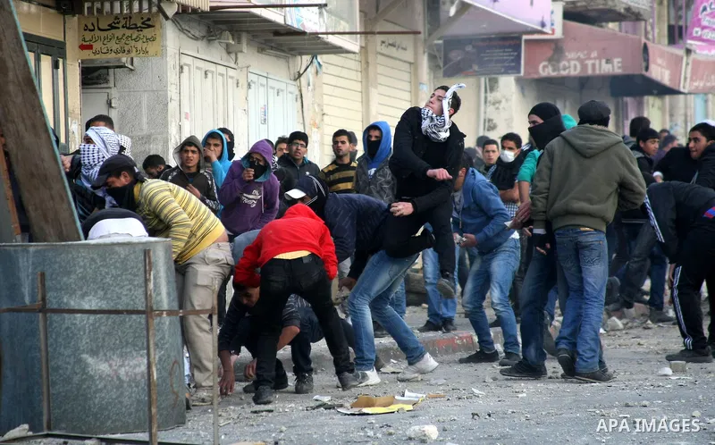Palestinian protesters throw stones towards Israeli security forces during clashes in the West Bank city of Hebron, on February 24, 2013 following the death of a Palestinian prisoner held in Israel. Some 3,000 Palestinia...