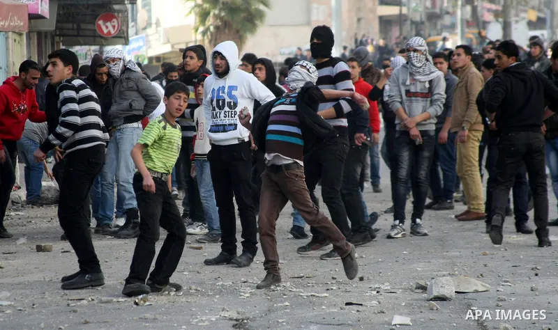 Palestinian protesters throw stones towards Israeli security forces during clashes in the West Bank city of Hebron, on February 24, 2013 following the death of a Palestinian prisoner held in Israel. Some 3,000 Palestinia...