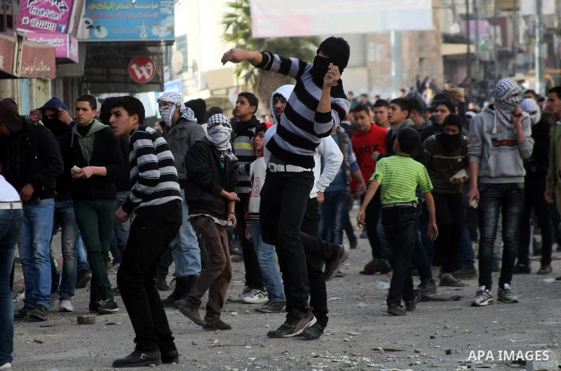 Palestinian protesters throw stones towards Israeli security forces during clashes in the West Bank city of Hebron, on February 24, 2013 following the death of a Palestinian prisoner held in Israel. Some 3,000 Palestinia...