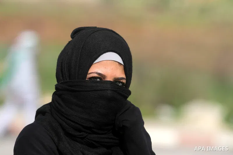 A Palestinian female protester wears a mask during clashes next to the Israeli military prison 'Ofer' in Beitunya, south of the West Bank city of Ramallah, on February 24, 2013 following the death of a Palestinian prison...