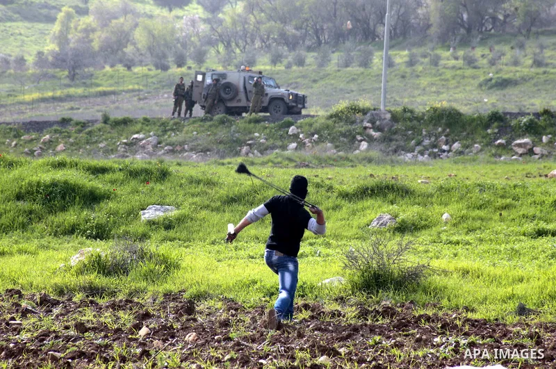 A Palestinian protester hurls stones at Israeli border police during clashes at Hawwara military checkpoint near the West Bank city of Nablus, on February 24, 2013 following the death of a Palestinian prisoner held in Is...
