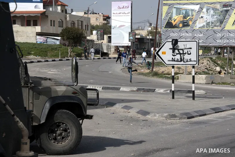 Palestinian protesters throw stones at Israeli border police during clashes at Hawwara military checkpoint near the West Bank city of Nablus, on February 24, 2013 following the death of a Palestinian prisoner held in Isr...