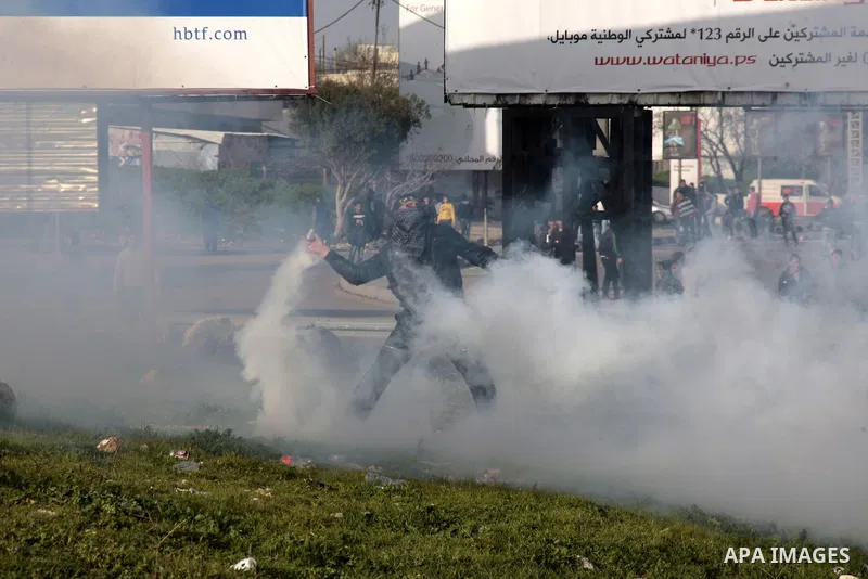 A Palestinian protester throws back a tear gas canister fired by Israeli border police during clashes at Hawwara military checkpoint near the West Bank city of Nablus, on February 24, 2013 following the death of a Palest...