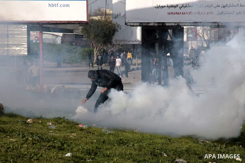 A Palestinian protester throws back a tear gas canister fired by Israeli border police during clashes at Hawwara military checkpoint near the West Bank city of Nablus, on February 24, 2013 following the death of a Palest...