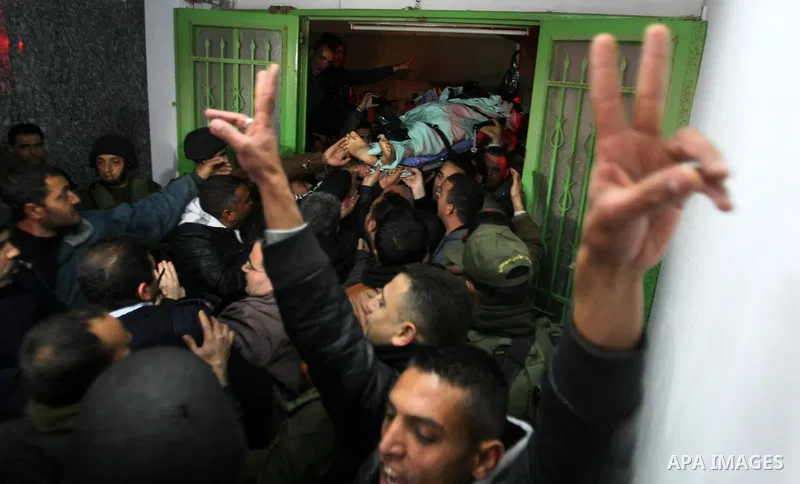 Palestinian mourners carry the body of Arafat Jaradat, a Palestinian prisoner who was killed in Israeli prison upon his arrival to the al-Ahly hospital in the West Bank city of Hebron, on February 23, 2013. The cause of...