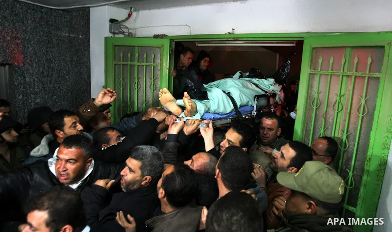Palestinian mourners carry the body of Arafat Jaradat, a Palestinian prisoner who was killed in Israeli prison upon his arrival to the al-Ahly hospital in the West Bank city of Hebron, on February 23, 2013. The cause of...