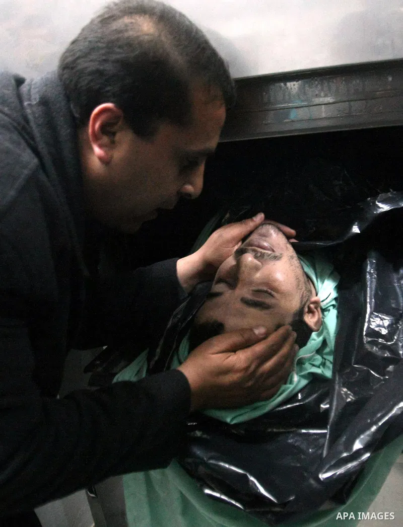 A Palestinian relative mourns on the body of Arafat Jaradat, a Palestinian prisoner who was killed in Israeli prison upon his arrival to the al-Ahly hospital in the West Bank city of Hebron, on February 23, 2013. The cau...